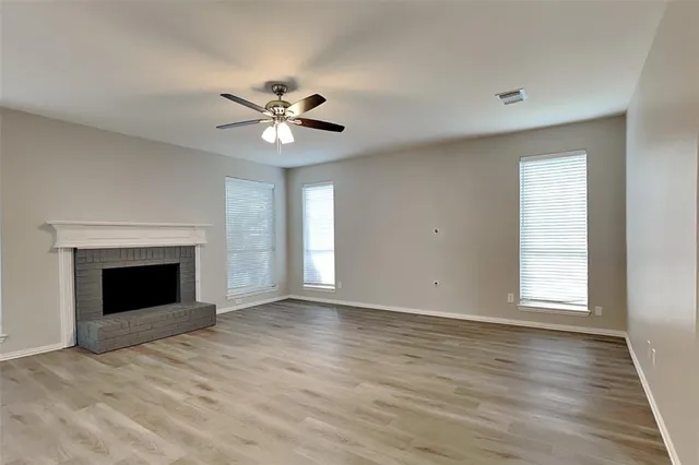 a view of an empty room with a window and a fireplace