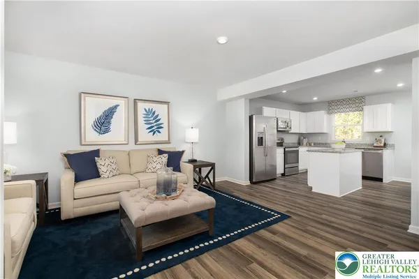 a living room with furniture and kitchen view