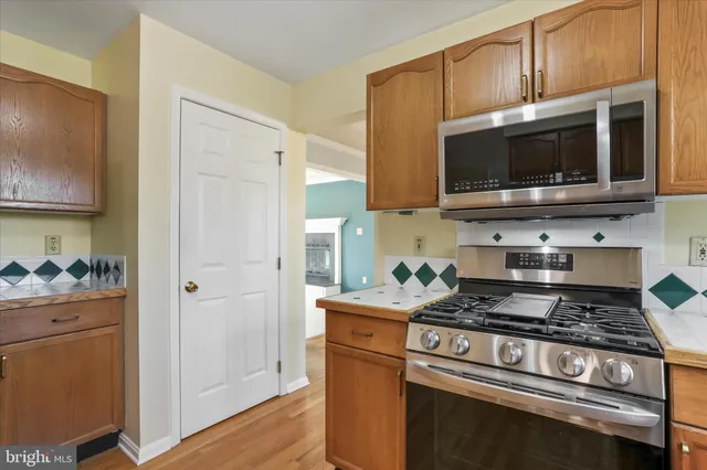 a kitchen with stainless steel appliances granite countertop a stove microwave and refrigerator
