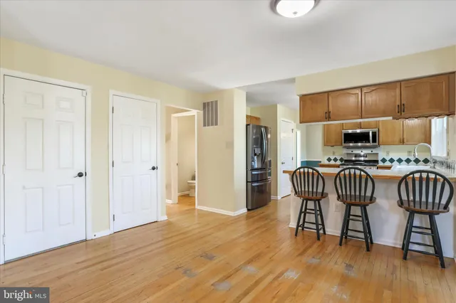 a kitchen with a table chairs refrigerator and wooden cabinets