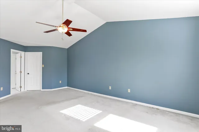 a view of a room with a ceiling fan and window