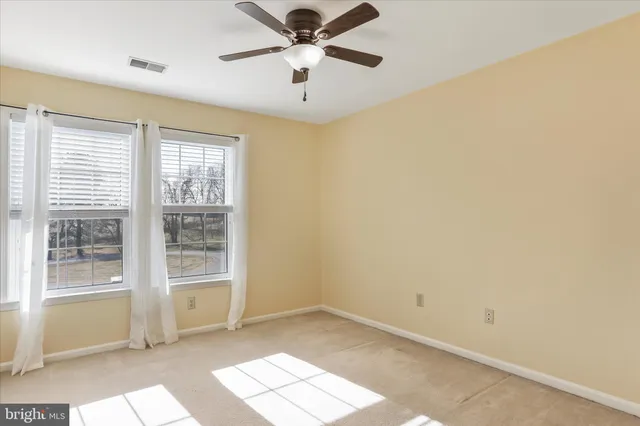 a view of empty room with ceiling fan