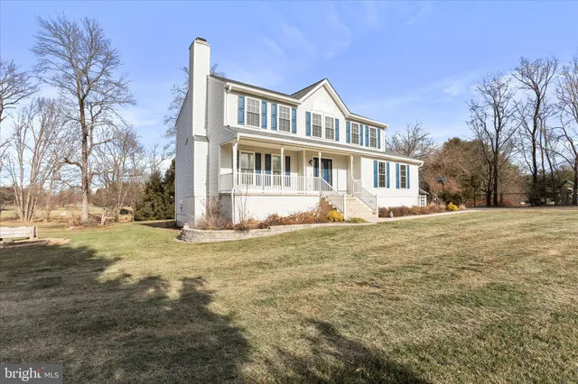 a front view of residential houses with yard and trees