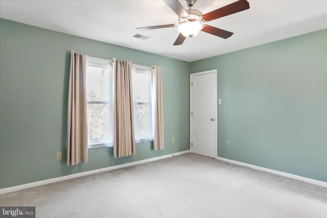 an empty room with a chandelier fan and a chandelier fan