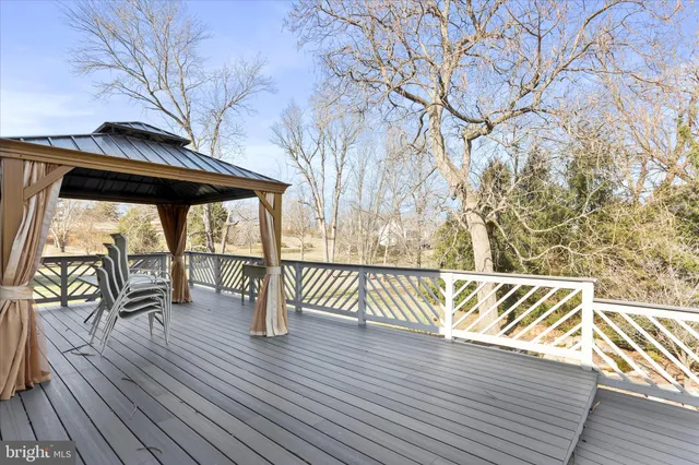 a view of a house with wooden deck and furniture