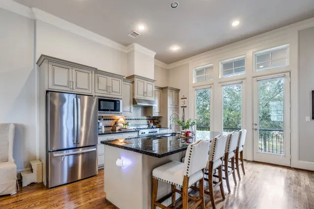 a kitchen with a refrigerator a stove a dining table and chairs