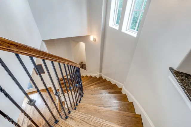 a view of a hallway with wooden floor and staircase