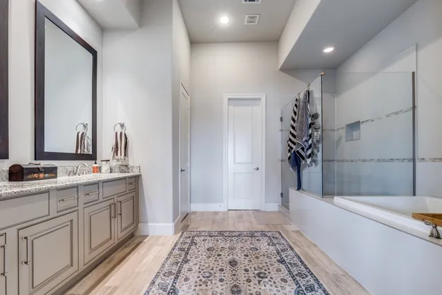 a bathroom with a tub sink and mirror