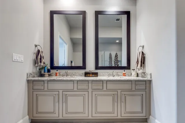 a bathroom with double sink and a mirror
