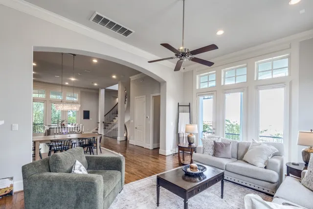 a living room with furniture ceiling fan and a large window