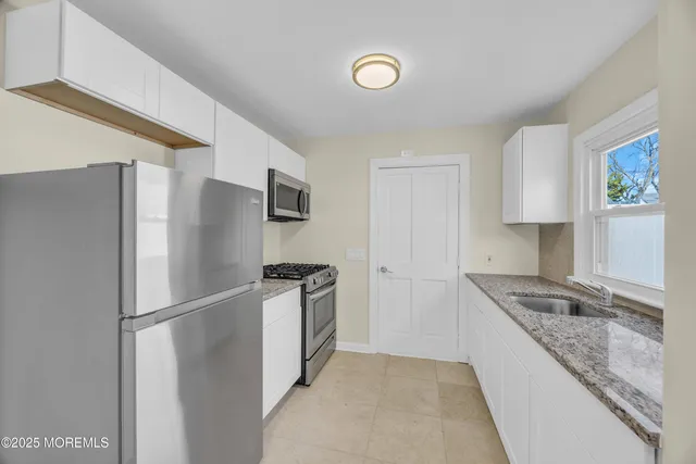 a kitchen with stainless steel appliances white cabinets and stove