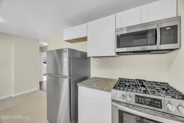 a kitchen with granite countertop a sink a stove and a granite counter top