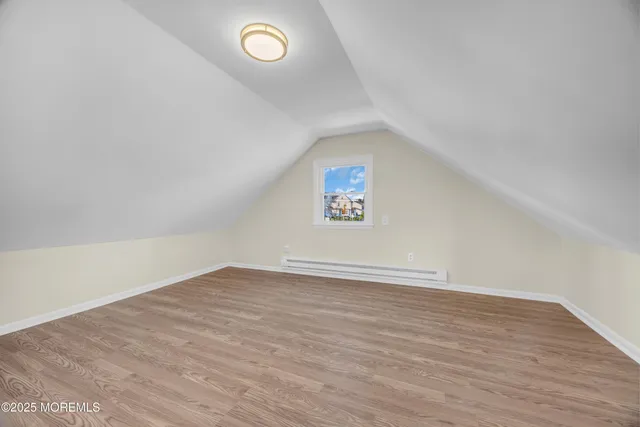 a view of an empty room with wooden floor and closet