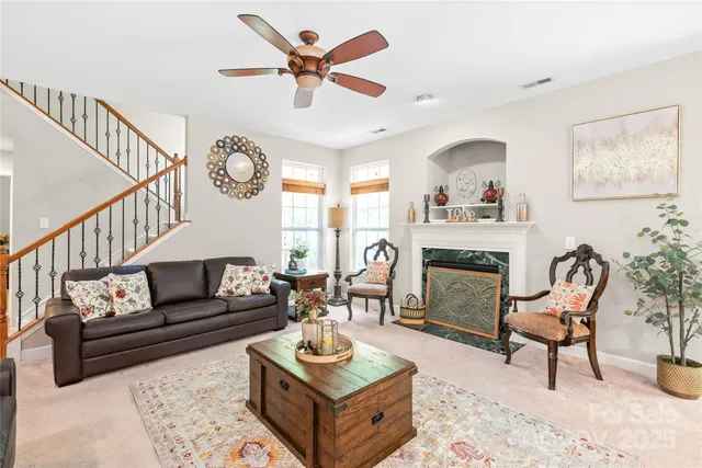 a living room with furniture a fireplace and a large window
