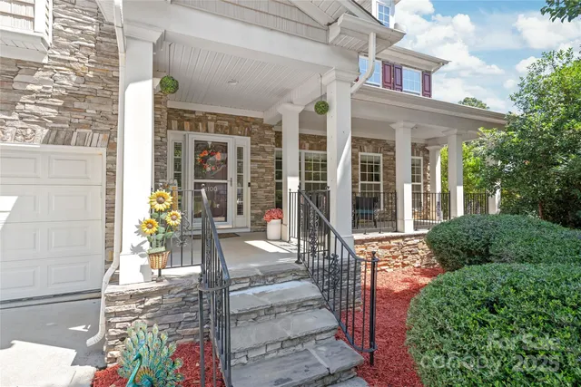 a front view of a building with a garden and plants