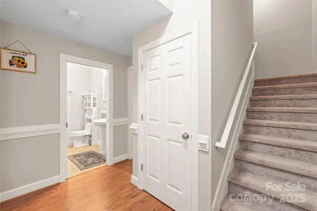 a view of a bedroom with wooden floor and white walls