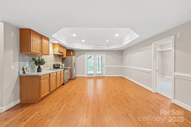 a large kitchen with wooden floor and stainless steel appliances