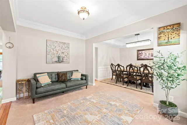 a living room with furniture flowerpot and a chandelier