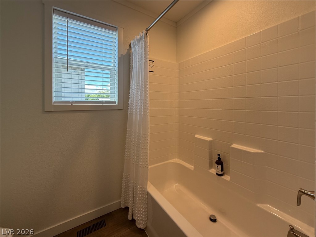 464 Box Canyon Road Alamo, NV 89001 - Photo 35 of 48 Tiled walls surround a classic soaking tub under a bright window in this cozy bathroom.