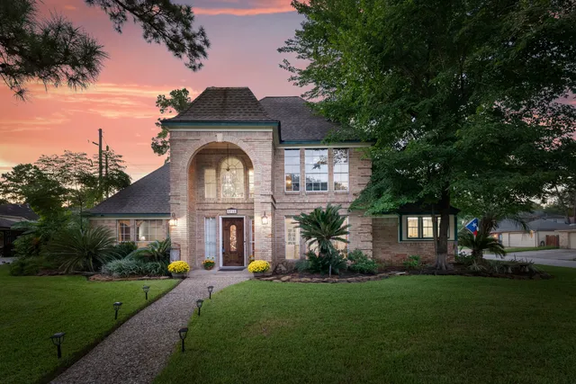 a front view of a house with a garden and plants