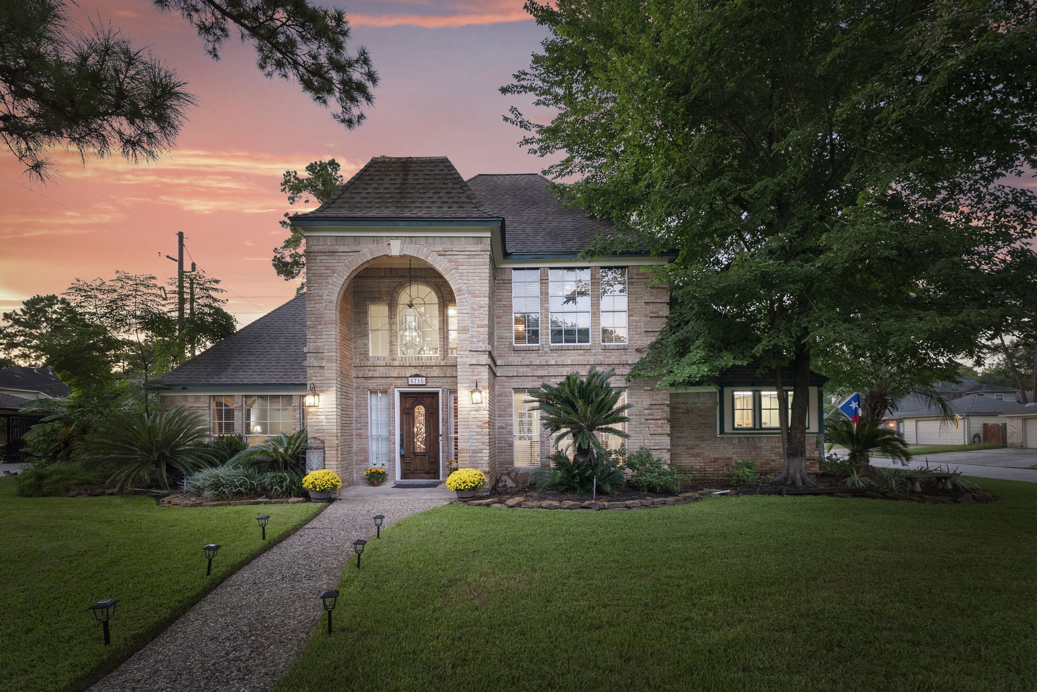 a front view of a house with a garden and plants