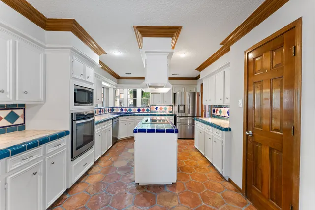 a kitchen with stainless steel appliances granite countertop a refrigerator and a stove