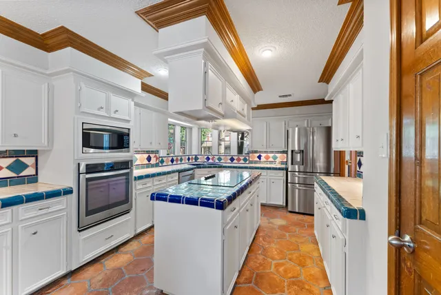 a kitchen with granite countertop a sink and stainless steel appliances
