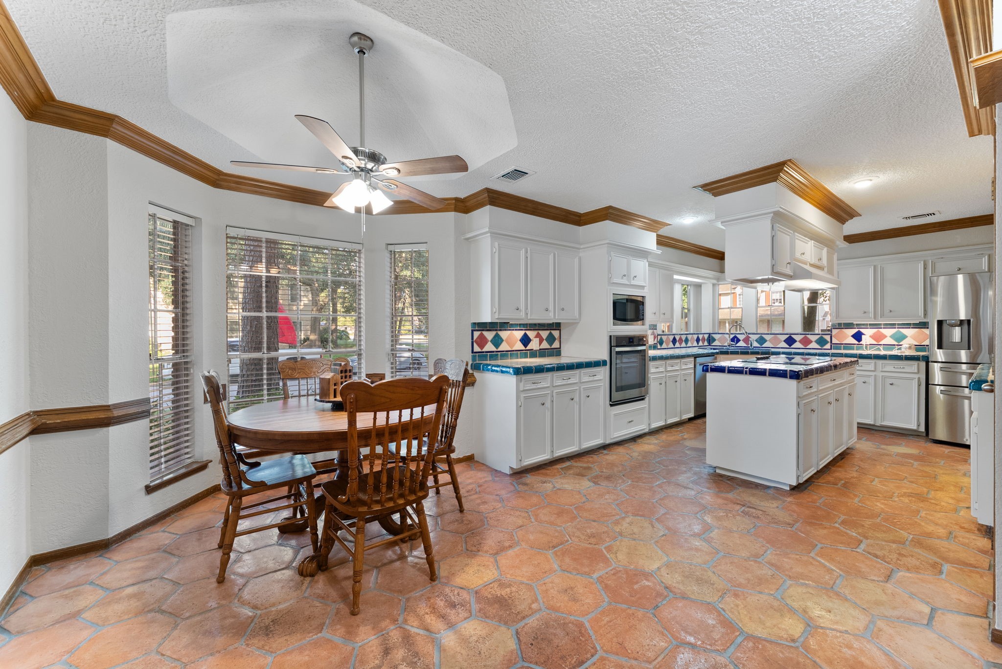 5718 Glenmere Lane Spring, TX 77379 - Photo 13 of 43 a kitchen with stainless steel appliances kitchen island granite countertop a table chairs and a refrigerator