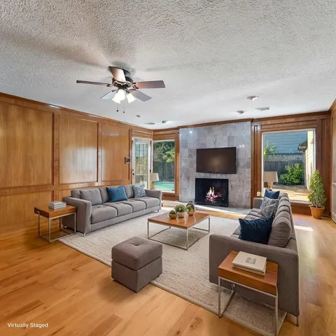 a living room with furniture ceiling fan and a fireplace