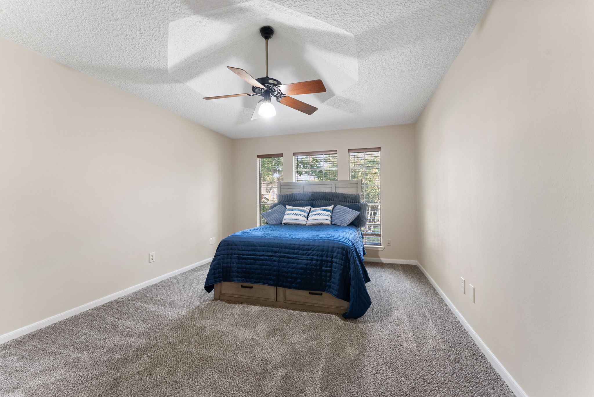 5718 Glenmere Lane Spring, TX 77379 - Photo 31 of 43 a spacious bedroom with a bed and a chandelier