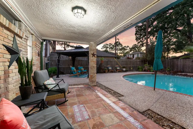 a view of a patio with chairs and a large tree
