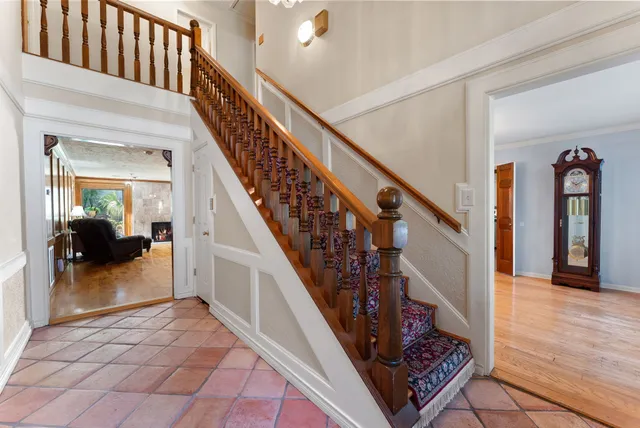 a view of staircase with lots of frames on wall and a rug