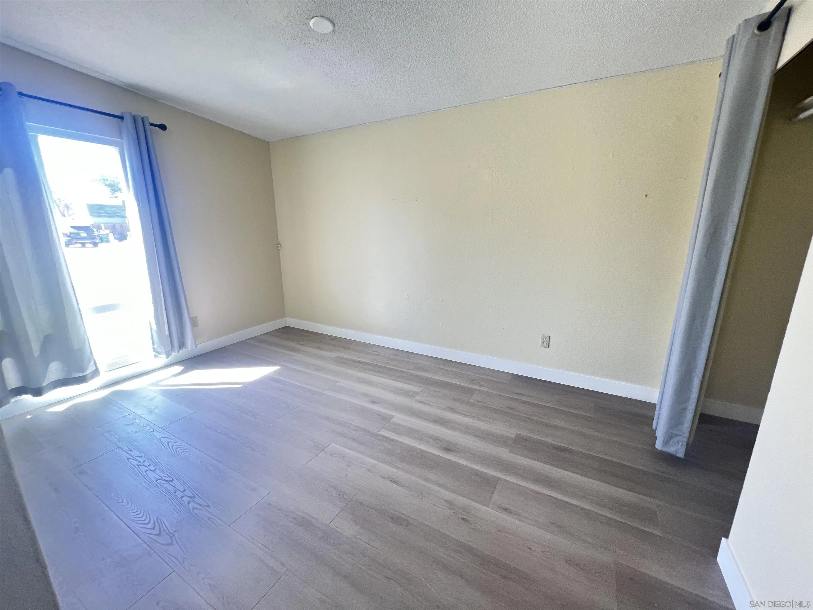 9267 Fairlawn Street Santee, CA 92071 - Photo 10 of 12 an empty room with wooden floor and windows