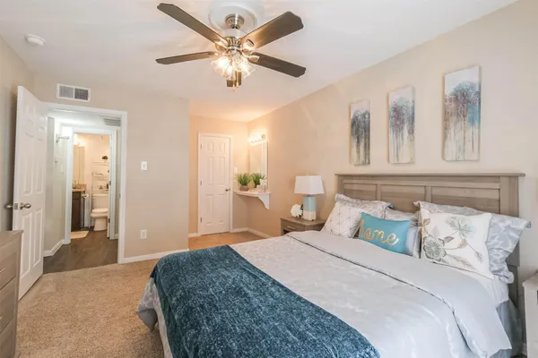 a bedroom with a large bed and a chandelier