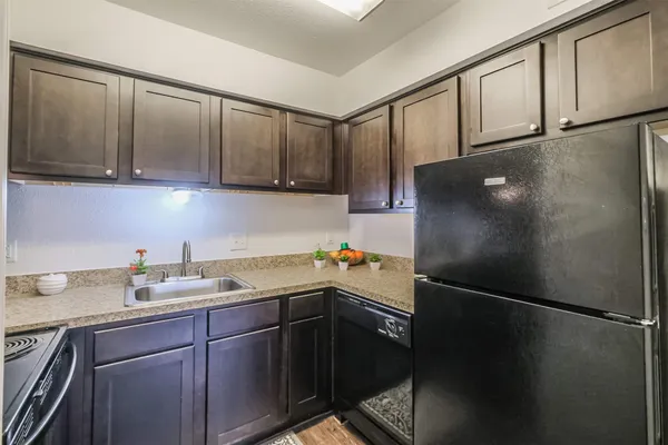 a kitchen with a sink a refrigerator and cabinets