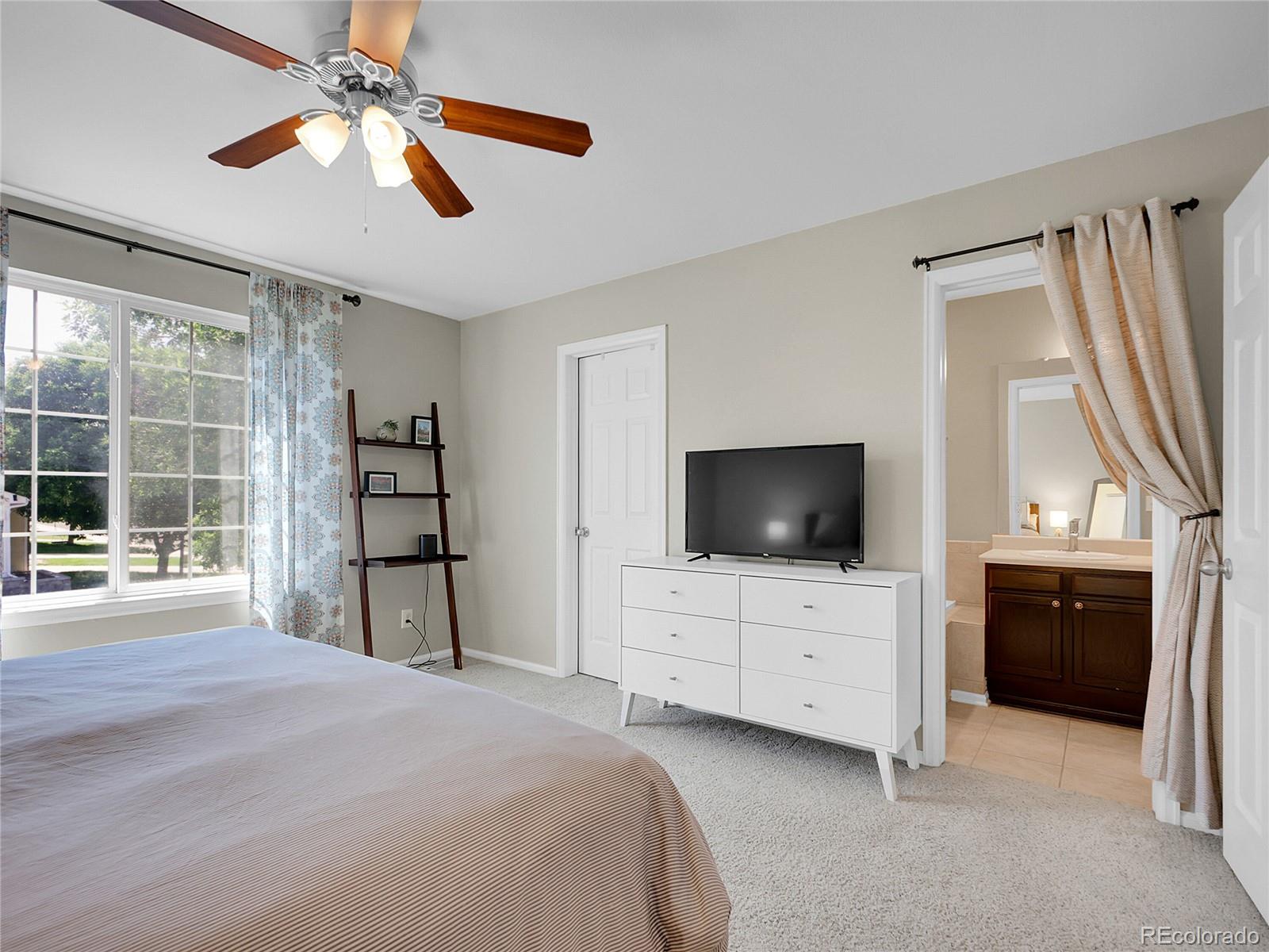 1234 Riddlewood Lane Highlands Ranch, CO 80129 - Photo 12 of 25 a bedroom with a bed and a flat screen tv