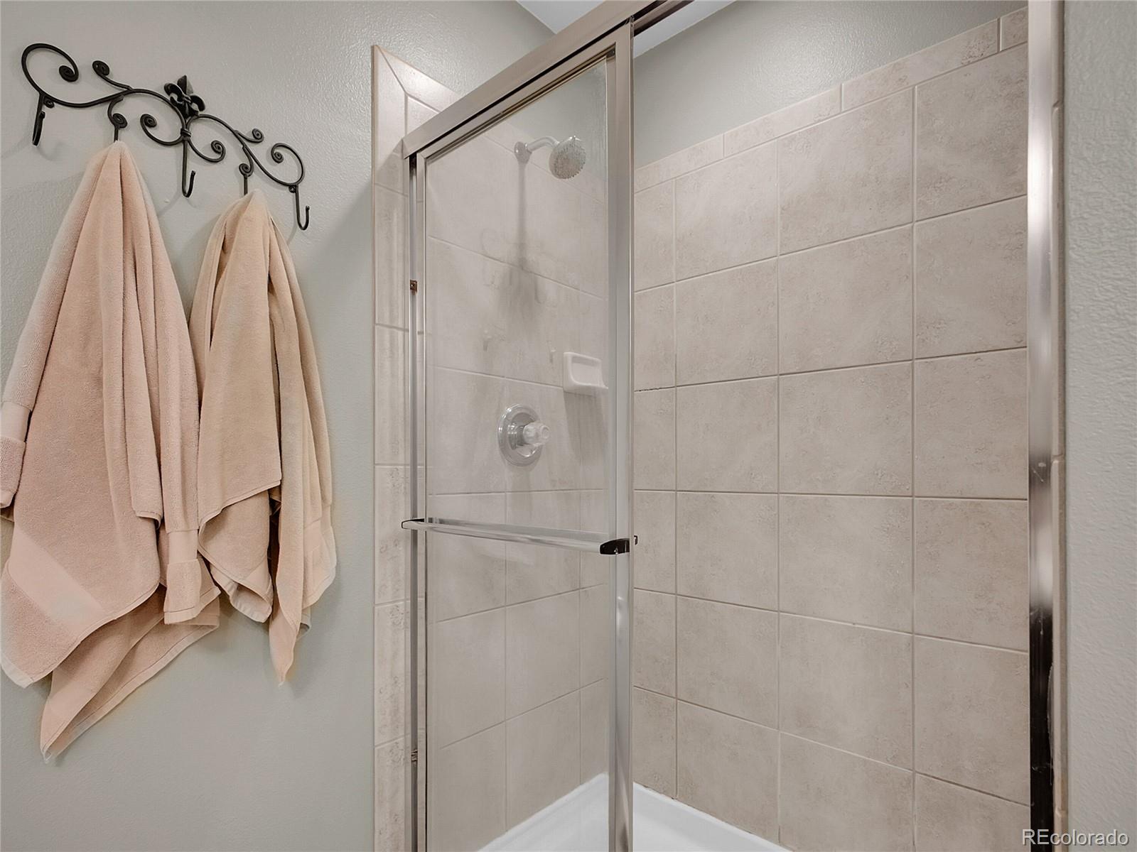 1234 Riddlewood Lane Highlands Ranch, CO 80129 - Photo 15 of 25 a bathroom with a shower and a glass door