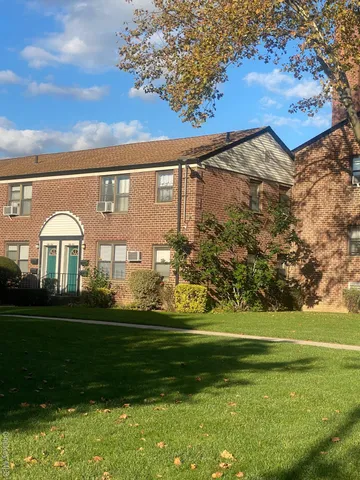 an empty room with wooden floor cabinet and windows