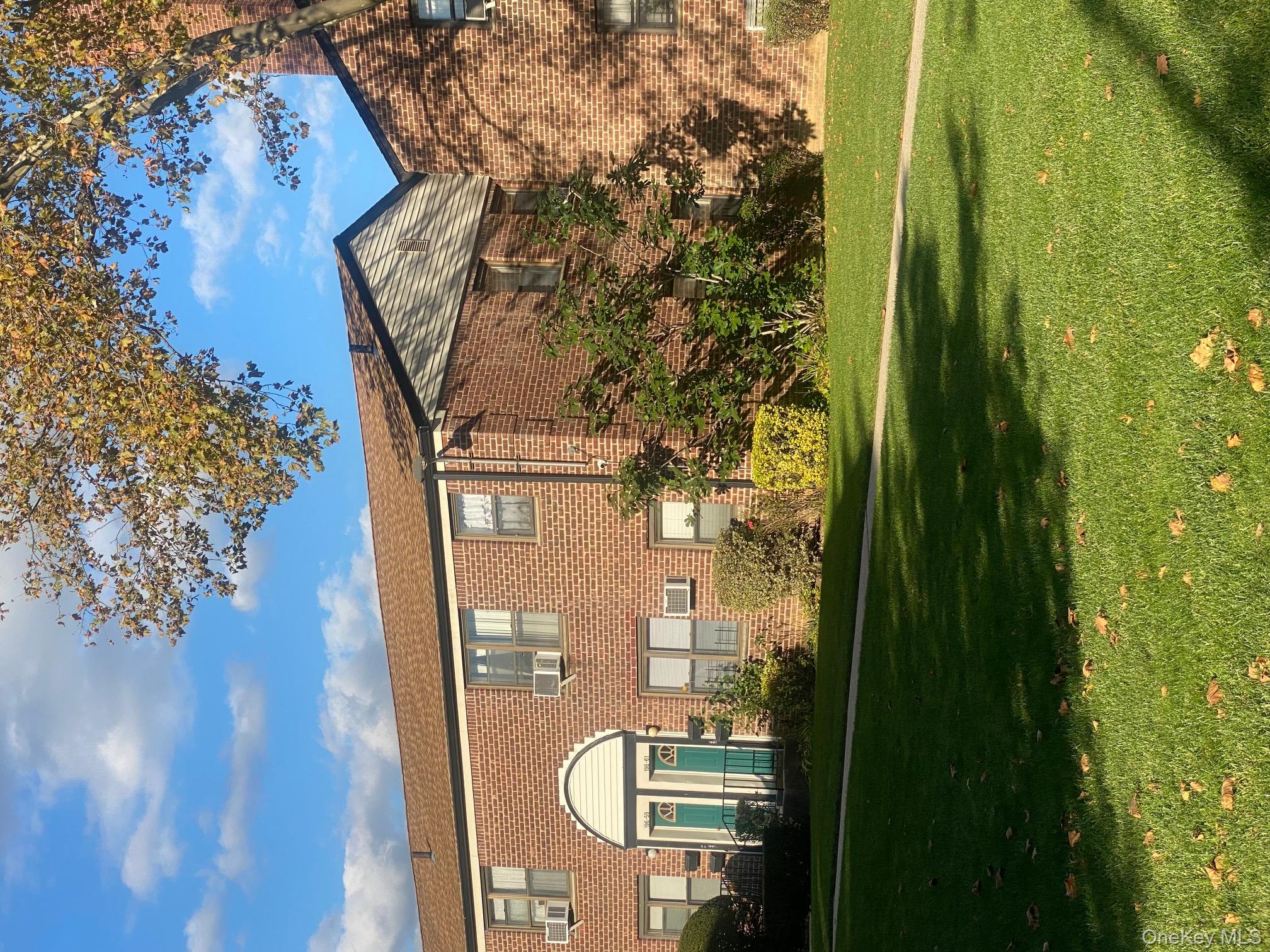 196-61 69th Avenue, Unit 1 Queens, NY 11365 - Photo 11 of 13 a front view of a house with a yard