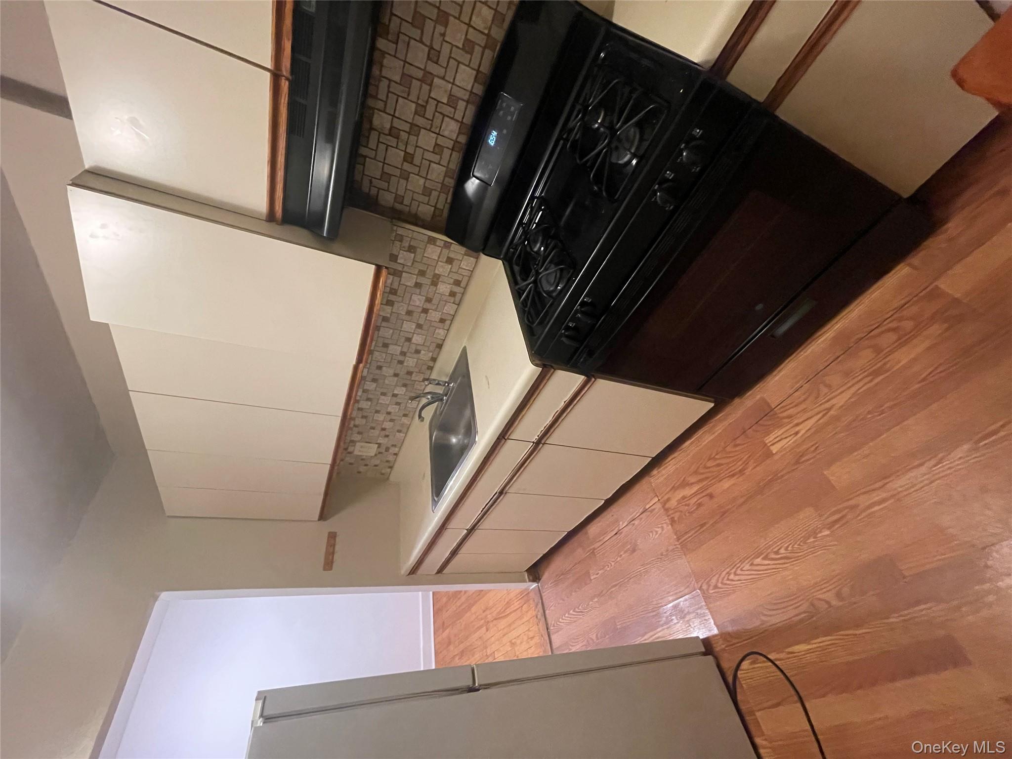 196-61 69th Avenue, Unit 1 Queens, NY 11365 - Photo 6 of 13 a stove top oven sitting inside of a kitchen