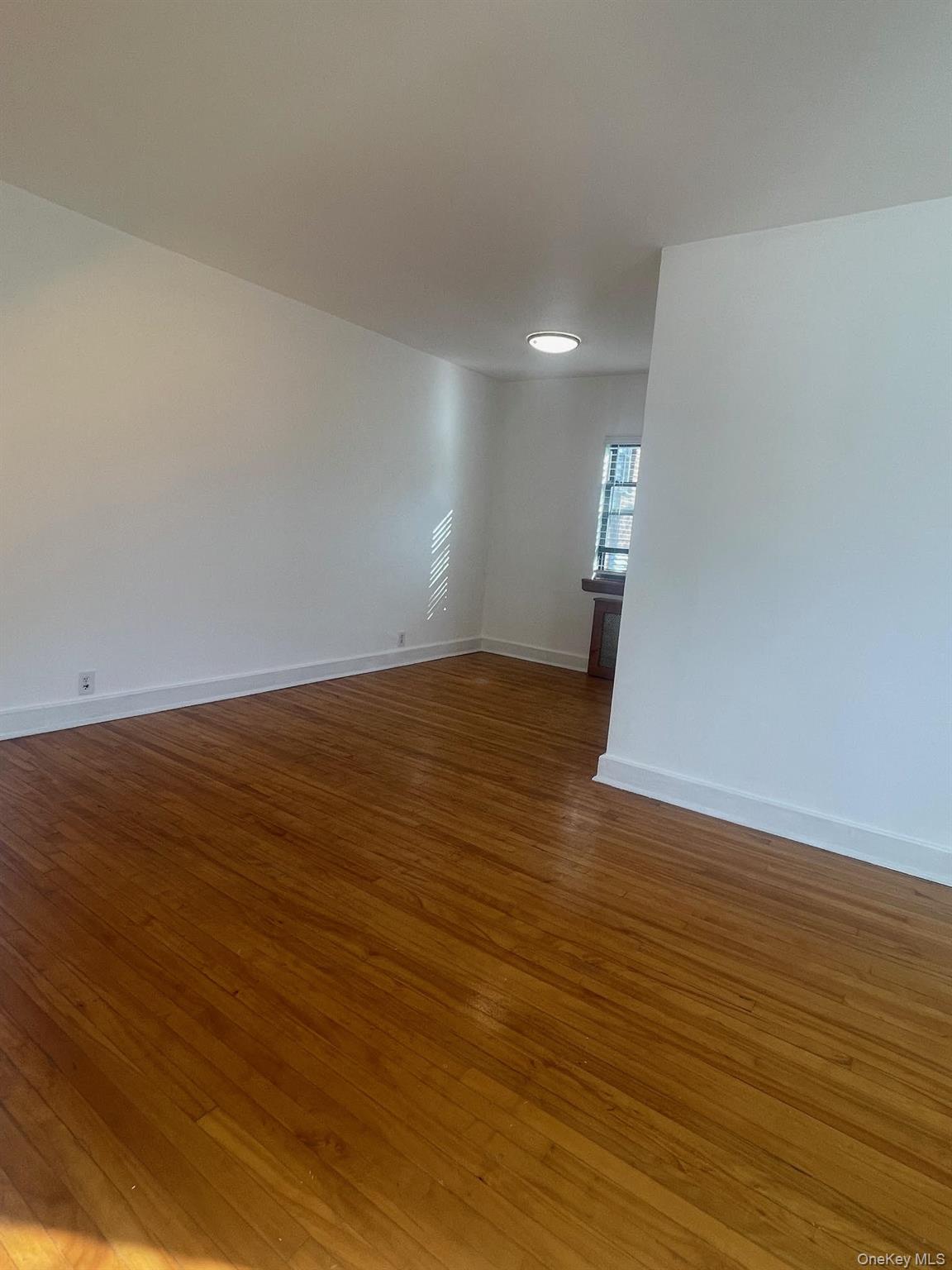 196-61 69th Avenue, Unit 1 Queens, NY 11365 - Photo 8 of 13 a view of empty room with wooden floor