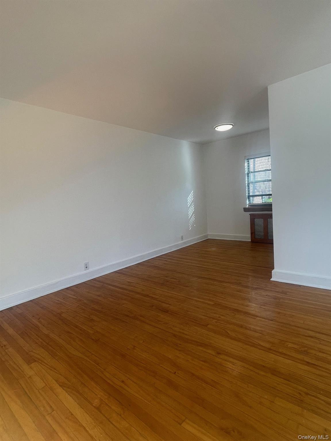 196-61 69th Avenue, Unit 1 Queens, NY 11365 - Photo 9 of 13 a view of empty room with wooden floor
