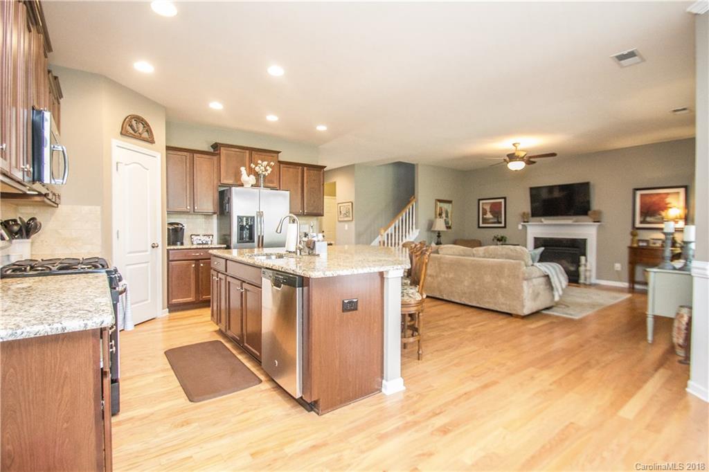 4016 Perth Road Indian Land, SC 29707 - Photo 11 of 28 a kitchen with stainless steel appliances kitchen island granite countertop a stove top oven a sink a dining table and chairs