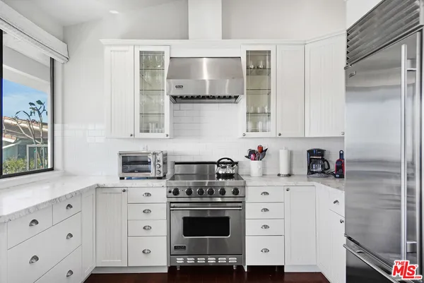 a kitchen with stainless steel appliances white cabinets and a stove