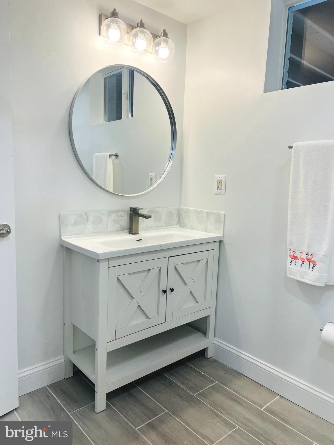 8802 2nd Avenue Silver Spring, MD 20910 - Photo 49 of 68 a bathroom with a sink a mirror and vanity
