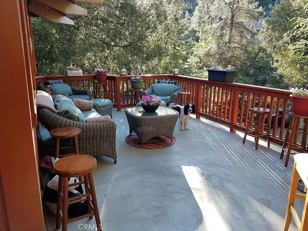 a balcony with wooden floor barbeque oven and outdoor seating