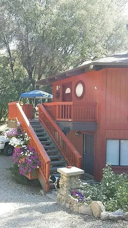 a view of a wooden house with a bench next to a road