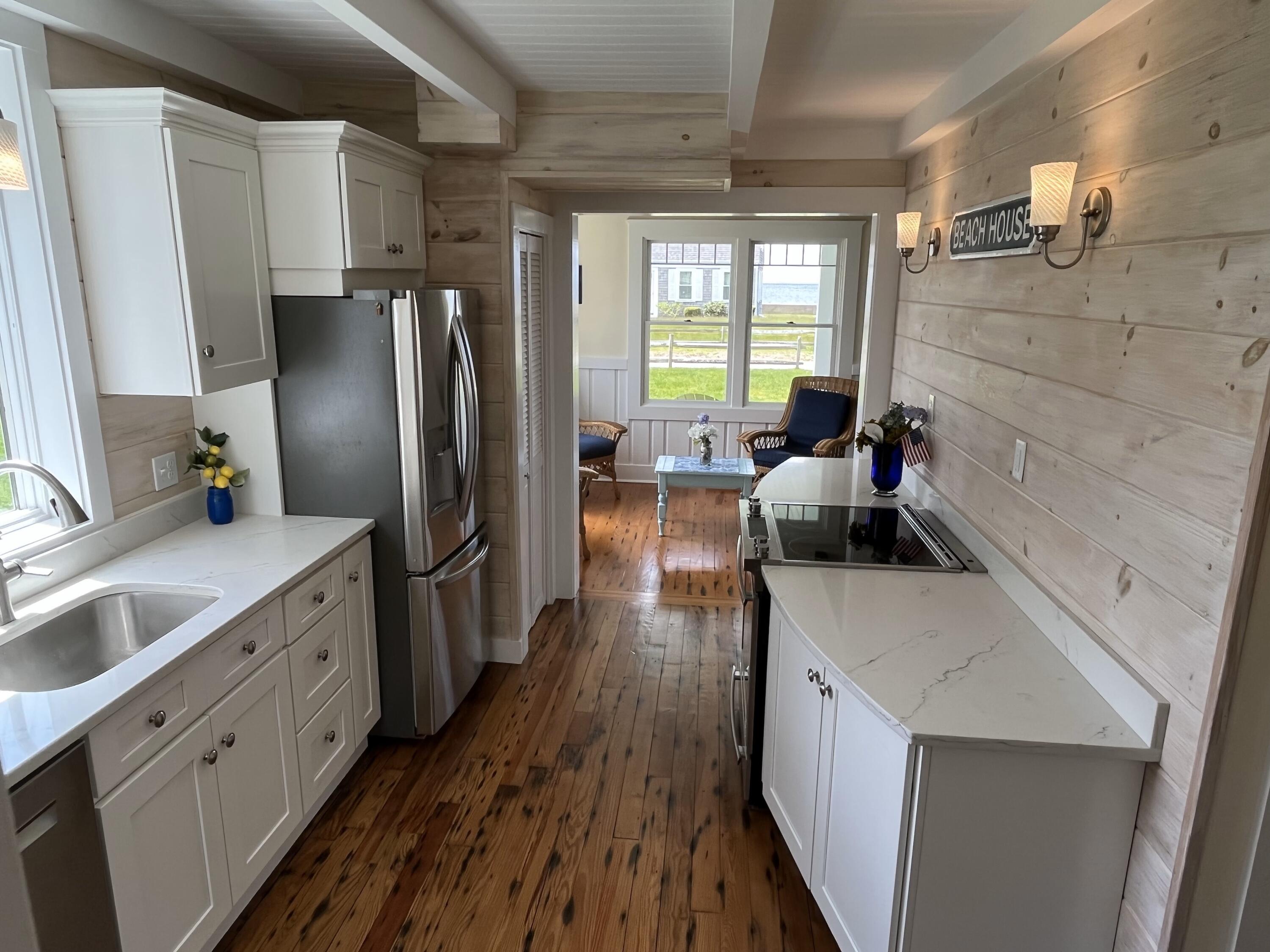 32 Shore Road West Yarmouth, MA 02673 - Photo 8 of 23 a kitchen with granite countertop a refrigerator a sink dishwasher stove and wooden floor