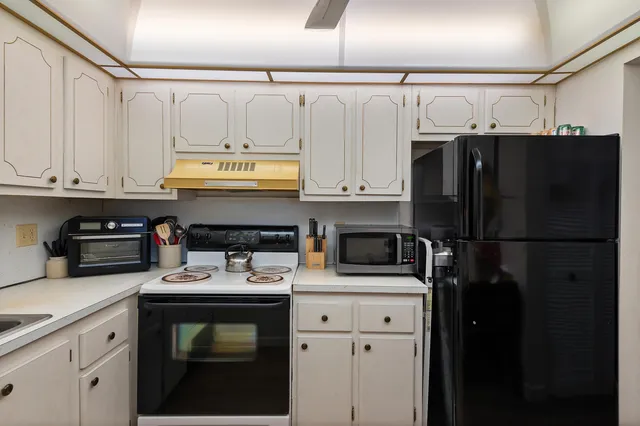 a kitchen with a refrigerator and a stove top oven