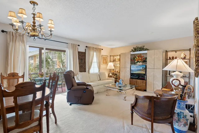 a living room with fireplace furniture and a chandelier